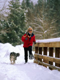 Buy A Woman with Her Canine Companion by Her Side, is Snowshoeing in the Hills at AllPosters.com