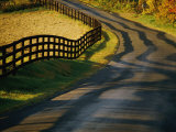 Twilight View of a Wooden Fence and its Shadow Along a Country Road