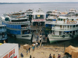 Half a Dozen Riverboats Form a Geometric Wedge as They are Being Loaded with Goods