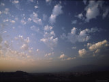 Buy Puffy White Clouds are Backlit by a Setting Sun at AllPosters.com