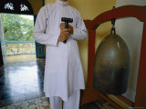 A Man Standing with a Mallet to Ring a Metal Bell