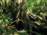 A Shirtless Man Emerges from the Hollow Trunk of a Tree