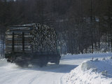 Buy A Lumber Truck Travels Along a Winding, Snow-Covered Hokkaido Road at AllPosters.com