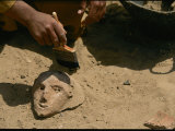 An Archeologist Brushes Sand Away from a Ceramic Artifact
