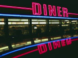 A Neon Diner Sign Relects off a Car Roof
