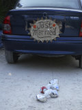 Buy A "Just Married" Sign and Tin Cans are Atached to the Back of a Car at AllPosters.com
