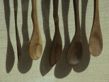 Close View of a Hanging Set of Wooden Spoons and Their Shadows