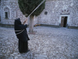 Buy A Nun Pulls on Ropes in a Courtyard at the Nea Moni Monastery at AllPosters.com