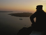 Buy A Silhouetted Greek Man Enjoys a Sunset from a High Point on Thira at AllPosters.com