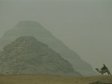 A Man Riding a Camel Passes Near the Step Pyramid of Djoser