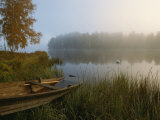 A Weathered Rowboat on the Shore of a Misty Lake