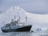 Tourists in a Kayak are Dwarfed by a Passenger Ship off Anvers Island
