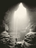 Buy A Man Stands in Front of a Skylit Cave Waterfall at AllPosters.com