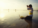 Buy A Kneeling Hindu Balinese Woman Prays and Gives Offerings at Sunset at AllPosters.com