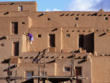 A Woman Climbs a Ladder to an Apartment in an Adobe Complex