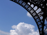 A Detailed Arch on the Eiffel Tower Against Blue Sky and Clouds