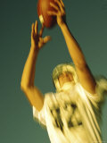 Football Player Reaching Up To Catch a Ball