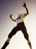 High Angle View of a Football Player Jumping in The Air with a Football