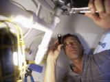 Buy Low Angle View of a Young Man Checking the Plumbing with a Flashlight at AllPosters.com