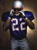 Portrait of an American Football Player Removing His Helmet