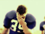 Football Player with His Hand Over His Face