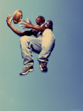 Low Angle View of a Man Catching a Football in Mid-Air