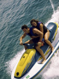 Mid Adult Couple Riding a Jet Ski in the Sea