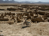 An Afghan Youth Rides His Bycicle by Houses