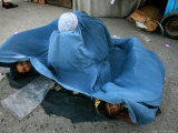 Afghans Girls Look out from the Burqa of Their Mother