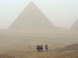 Tourists Ride Camels Through a Dust Storm at the Site of the Great Pyramids