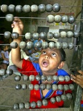 Buy Boy, 3, Counts on an Abacus at a School in Allahabad at AllPosters.com