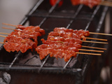 Several Skewers of Saucy Red Meat on a Grill Photographic Print