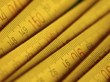 Close-up of Many Yellow Measuring Tapes with Numbers