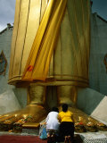 Worshippers at Feet of Standing Buddha Figure at Wat Indraram, Bangkok, Thailand
