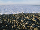 Whitewater From Crashing Waves Washes onto a Pebble Beach