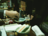 Japanese Man Extinquishes a Cigarette in an Ashtray