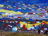 Pilgrim Stringing Up Prayer Flags with Mountains in Background