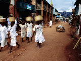 Buy Women of a Religious Community Carry Baskets on their Heads Through the Soatanana Village at AllPosters.com