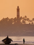 Lone Person Walking Along Lighthouse Beach in Early Morning