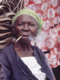 Old Haitian Woman Smoking a Pipe in Front of Her Hut