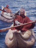 Indian Fishermen in Colorful Knit Hats Row across Lake Titicaca in Totora Boats Made of Reeds, Peru