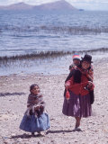 Mother and Two Children Holding Ball of Yarn, Andean Highlands of Bolivia