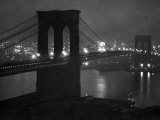 Glittering Night View of the Brooklyn Bridge Spanning the Glassy Waters of the East River