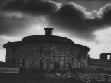 Buy Round Stone Shaker Barn Dramatically Highlighted with Darkening Clouds at AllPosters.com