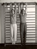 Buy Health Club Owner Terry Hunt, Trainer of Movie Stars, Hanging from Horizontal Bars with Mary Astor at AllPosters.com