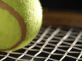 Close-Up of Tennis Ball on Webbing of Tennis Racket