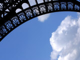 Intricate Architectural Designs on Eiffel Tower Against a Blue Sky with Fluffy Clouds
