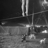 Two Small Children Watching Circus Performer Practicing on Tightrope, Her Legs Only Visible