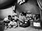 Eskimo Family Admiring their Modern Conveniences, a Victrola, a Sewing Machine and a Stove