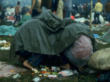 Several Youths Huddled under a Green Tarp, During the Woodstock Music and Art Fair